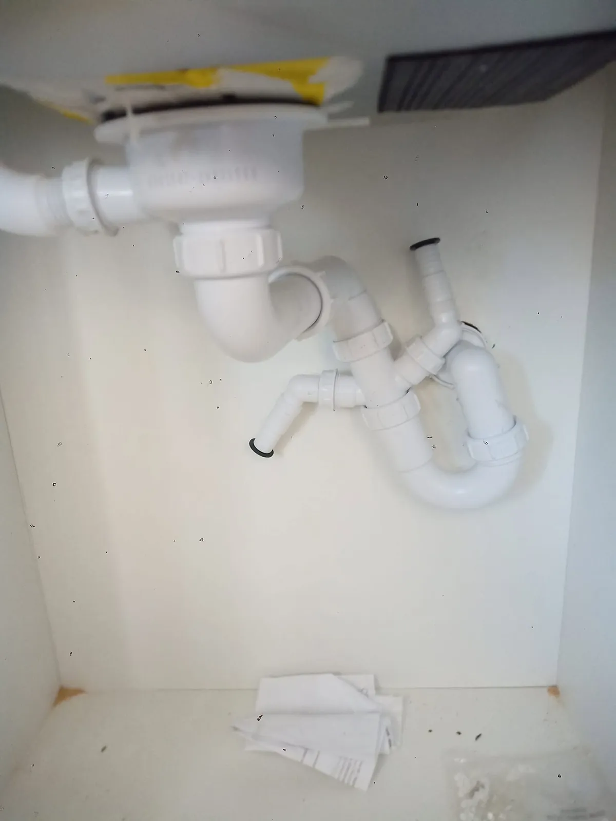Sifão de plástico branco montado debaixo de um lava-loiça
