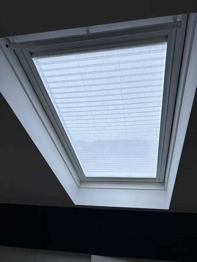 Estore plissado numa clarabóia, a filtrar a luz