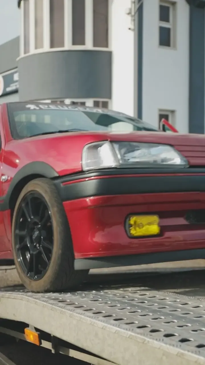 Peugeot 106 vermelho em cima de um reboque